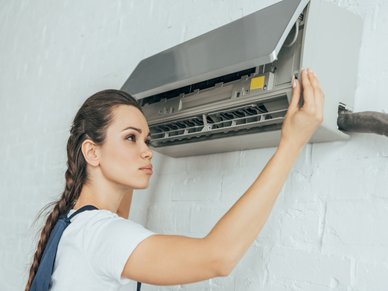 Profesional cualificada realizando mantenimiento en su Aire Acondicionado